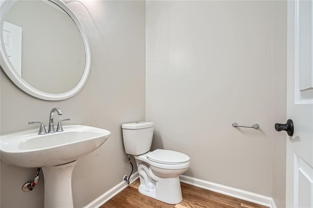 bathroom featuring hardwood / wood-style flooring and toilet