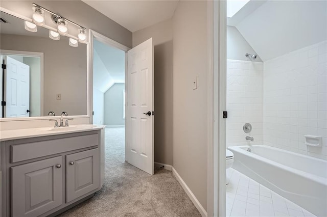 full bathroom with lofted ceiling, vanity, tiled shower / bath combo, and toilet