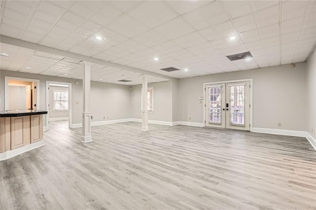 basement featuring wood-type flooring, a paneled ceiling, and french doors