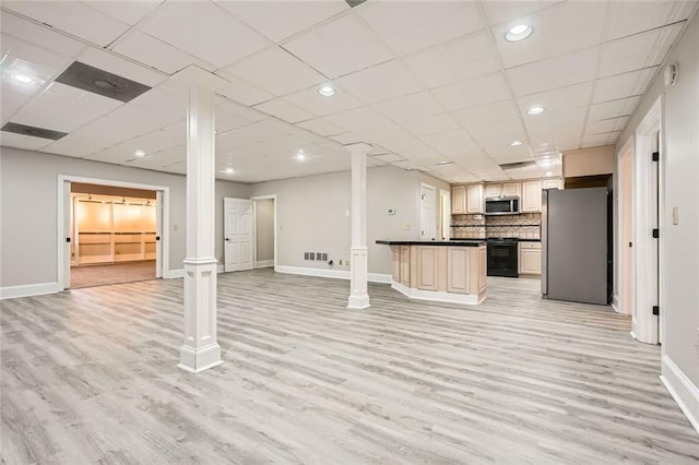 kitchen featuring appliances with stainless steel finishes, light hardwood / wood-style floors, decorative columns, and backsplash