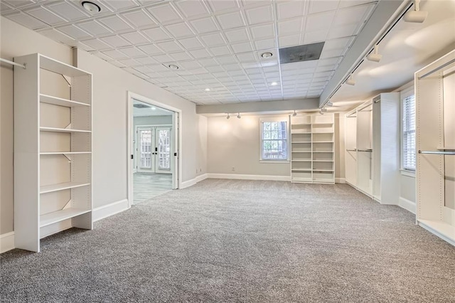 carpeted spare room with rail lighting and french doors