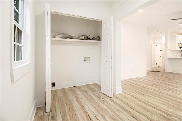 clothes washing area with hookup for a washing machine and light hardwood / wood-style flooring