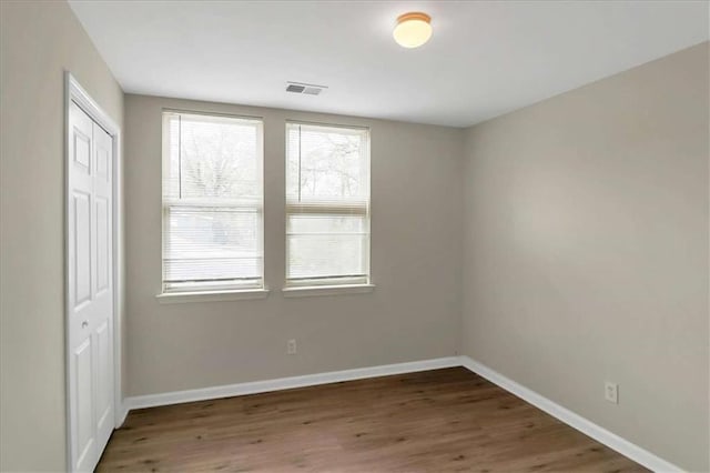 unfurnished room with dark wood-type flooring