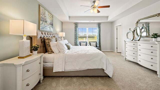 12086 Conrad Cir, Hampton, GA 30228 - bedroom featuring light colored carpet, a raised ceiling, a ceiling fan, and baseboards