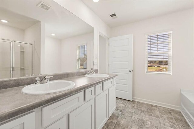 12086 Conrad Cir, Hampton, GA 30228 - bathroom featuring baseboards, double vanity, a bath, an enclosed shower, and recessed lighting