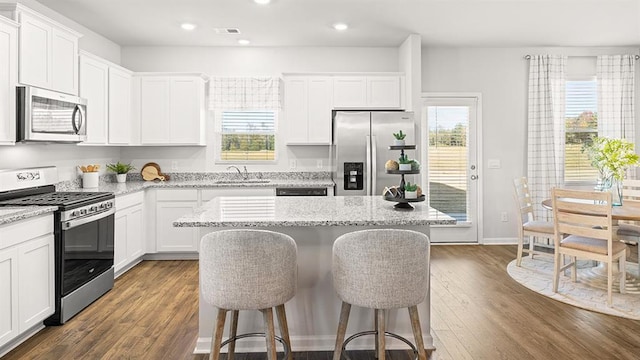 12086 Conrad Cir, Hampton, GA 30228 - kitchen featuring stainless steel appliances, a sink, a breakfast bar, recessed lighting, and white cabinets