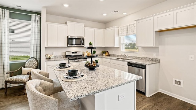 12086 Conrad Cir, Hampton, GA 30228 - kitchen featuring stainless steel appliances, a sink, dark wood-style floors, white cabinetry, and light stone counters
