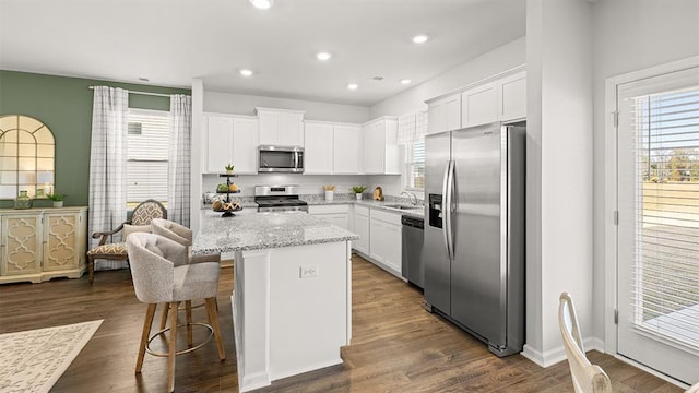 12086 Conrad Cir, Hampton, GA 30228 - kitchen featuring stainless steel appliances, a sink, a breakfast bar area, white cabinetry, and recessed lighting