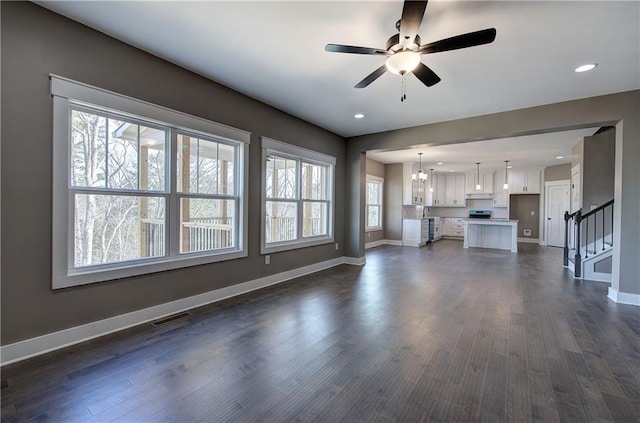 unfurnished living room featuring baseboards, stairs, visible vents, and dark wood-style flooring