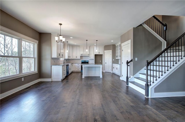 kitchen with white cabinetry, dark wood finished floors, baseboards, and stainless steel electric stove