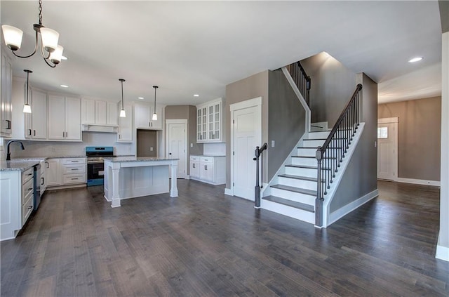 kitchen with electric stove, dark wood-style flooring, white cabinetry, and under cabinet range hood