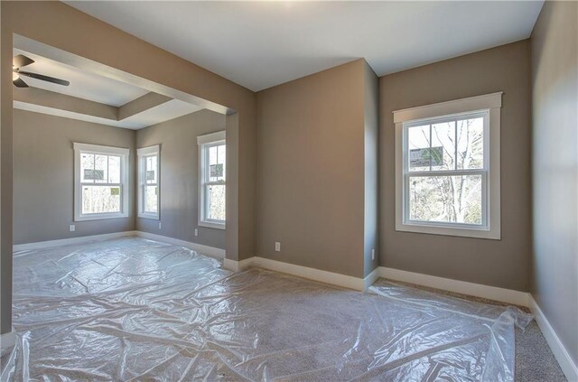 unfurnished room featuring a ceiling fan and baseboards