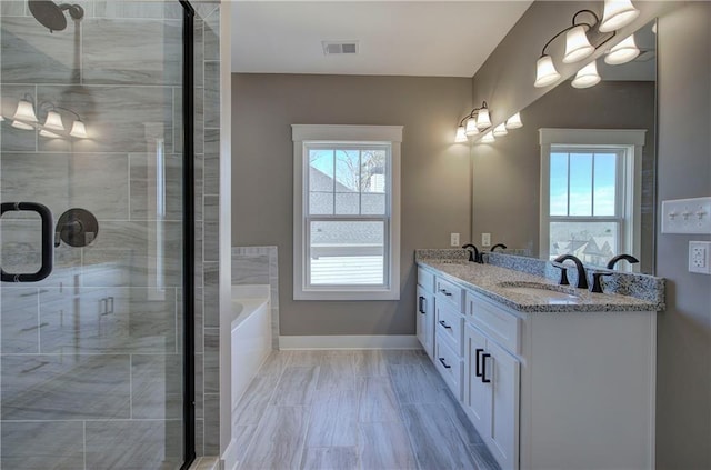 full bath with plenty of natural light, a stall shower, visible vents, and a sink