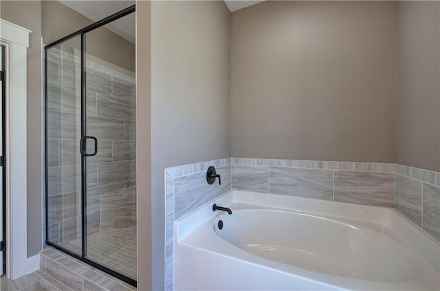 bathroom with a shower stall and a bath