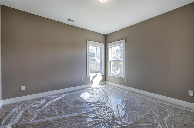 unfurnished room with visible vents and baseboards