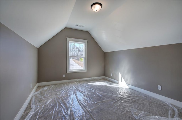 additional living space with vaulted ceiling, visible vents, and baseboards