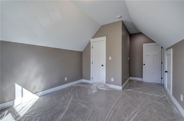 additional living space featuring lofted ceiling and baseboards