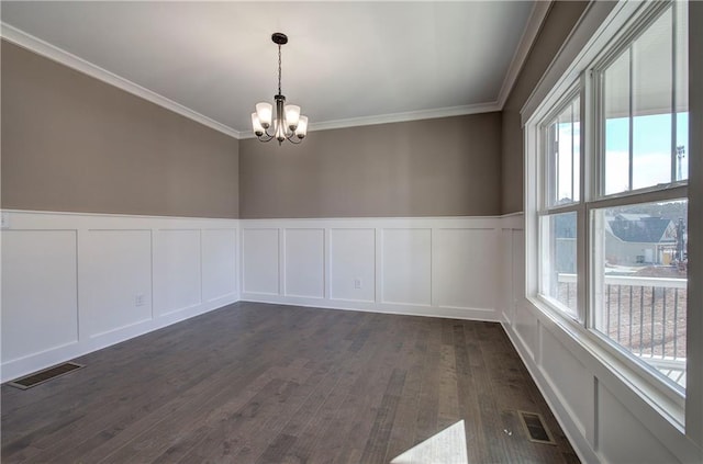 empty room with crown molding, visible vents, dark wood finished floors, and an inviting chandelier