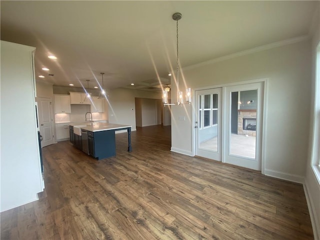 226 Montview Dr, Jefferson, GA 30549 - kitchen featuring open floor plan, dark wood-type flooring, light countertops, pendant lighting, and crown molding