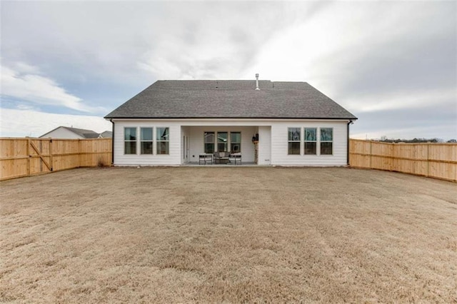 rear view of property with a yard and a patio area