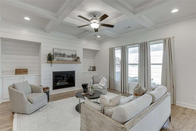 living room with coffered ceiling, beamed ceiling, ceiling fan, a fireplace, and light hardwood / wood-style floors