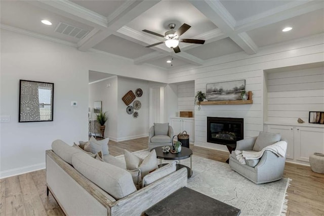 living room with coffered ceiling, a fireplace, beamed ceiling, and light wood-type flooring