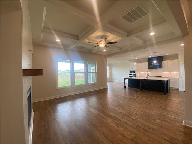 226 Montview Dr, Jefferson, GA 30549 - unfurnished living room with dark wood-style flooring, ceiling fan, a fireplace, baseboards, and beam ceiling