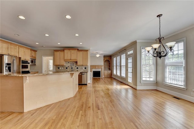 870 Longstone Lndg, Alpharetta, GA 30022 - kitchen with crown molding, light brown cabinetry, appliances with stainless steel finishes, a chandelier, and open floor plan