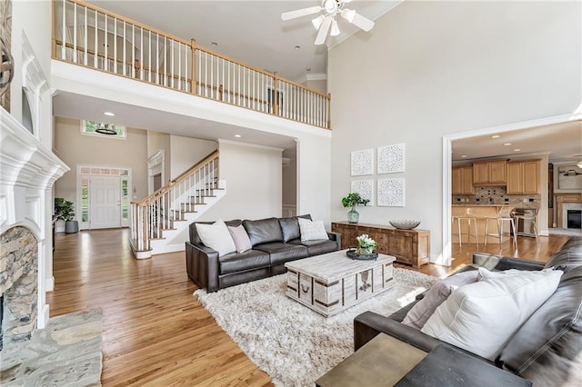 870 Longstone Lndg, Alpharetta, GA 30022 - living area with a high ceiling, a fireplace, stairway, a ceiling fan, and light wood-style floors