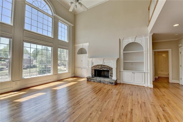 870 Longstone Lndg, Alpharetta, GA 30022 - unfurnished living room featuring crown molding, healthy amount of natural light, a ceiling fan, a high ceiling, and light wood-style floors