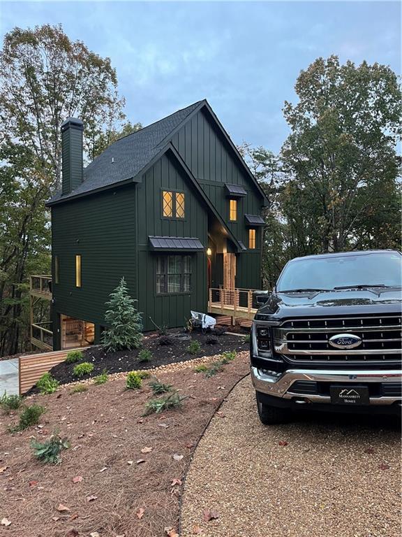 6 Huntington Pl, Dahlonega, GA 30533 - view of front of home with board and batten siding, a chimney, a shingled roof, and an attached garage