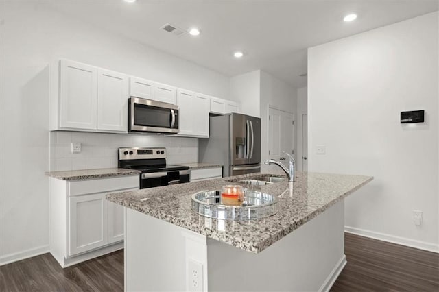 kitchen featuring backsplash, dark hardwood / wood-style floors, appliances with stainless steel finishes, and a kitchen island with sink