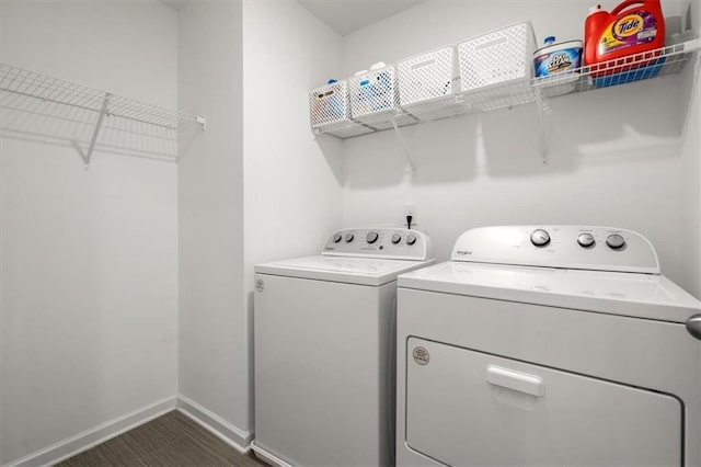 laundry area with dark tile patterned floors and washer and clothes dryer