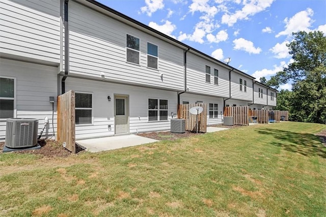 rear view of house featuring central air condition unit, a lawn, and a patio