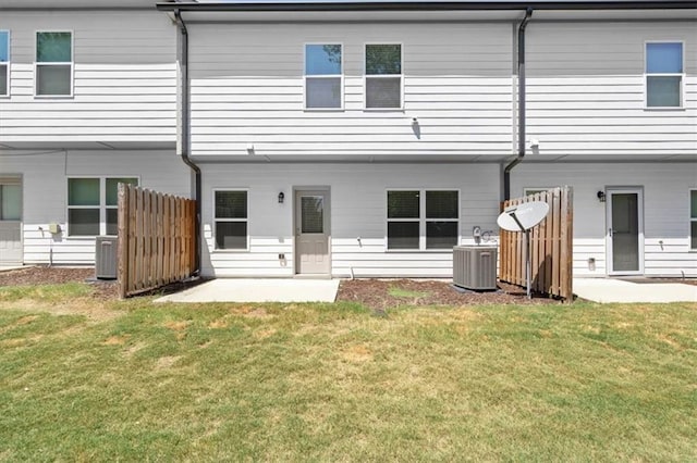 rear view of house with a lawn, a patio area, and central air condition unit