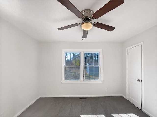 empty room featuring dark carpet and ceiling fan