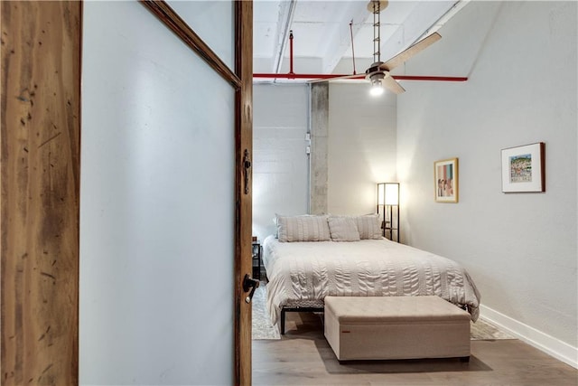 bedroom with light wood finished floors and baseboards