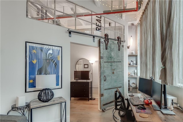 office featuring a barn door and wood finished floors