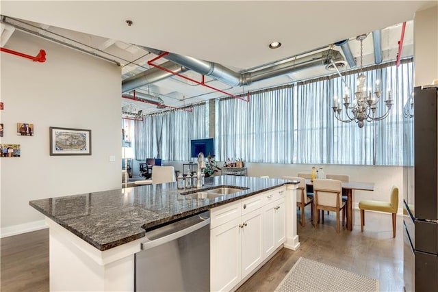 kitchen with refrigerator, a notable chandelier, stainless steel dishwasher, white cabinetry, and a sink