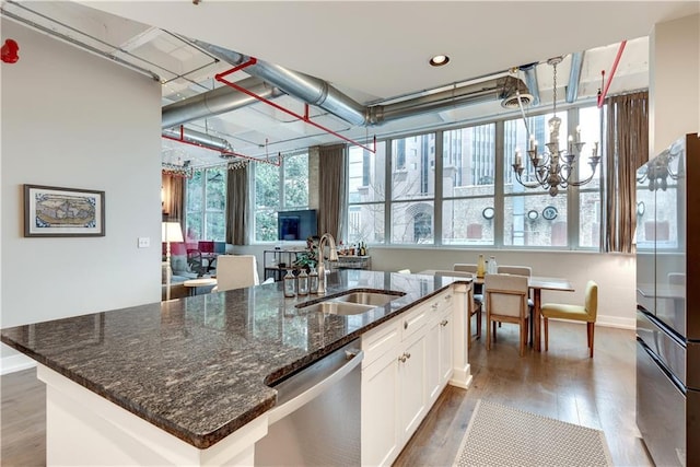 kitchen with dishwasher, dark wood-style flooring, a kitchen island with sink, white cabinetry, and a sink