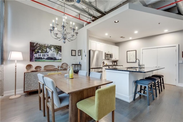 dining space with baseboards, a chandelier, dark wood finished floors, and recessed lighting