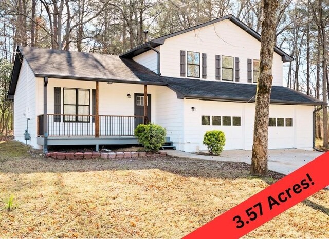 tri-level home featuring concrete driveway, a garage, covered porch, and roof with shingles