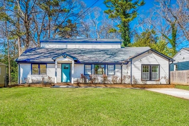 view of front of property with brick siding, fence, and a front lawn