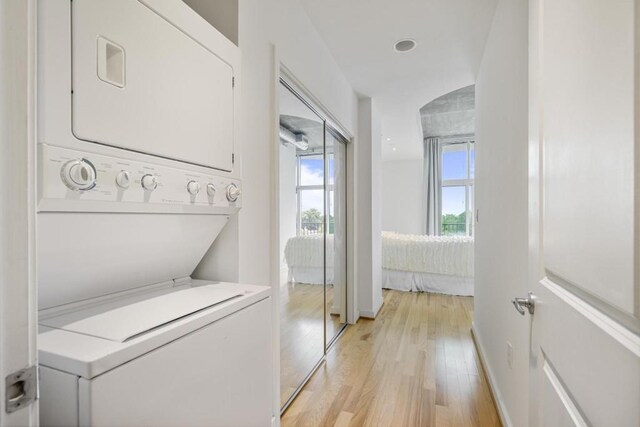 943 Peachtree St NE Unit 716, Atlanta, GA 30309 - laundry room with stacked washer and clothes dryer, light wood-style floors, and baseboards