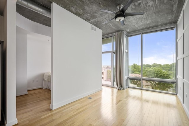 943 Peachtree St NE Unit 716, Atlanta, GA 30309 - spare room featuring floor to ceiling windows, light wood-style flooring, a ceiling fan, and baseboards