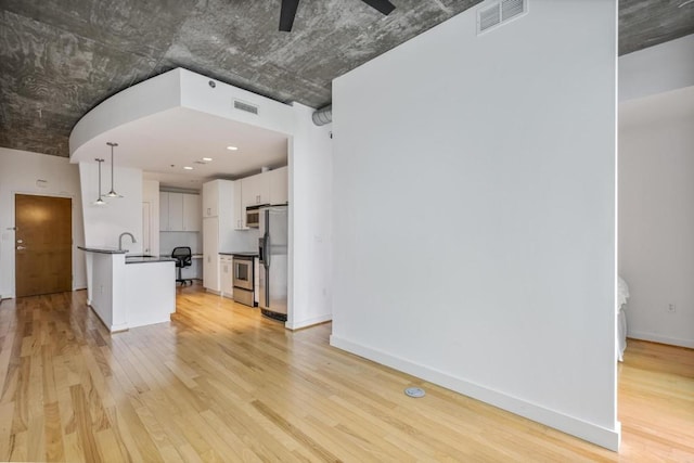 943 Peachtree St NE Unit 716, Atlanta, GA 30309 - unfurnished living room featuring light wood-style floors, a ceiling fan, baseboards, and a sink