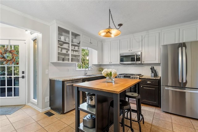 kitchen featuring butcher block counters, sink, white cabinetry, and stainless steel appliances