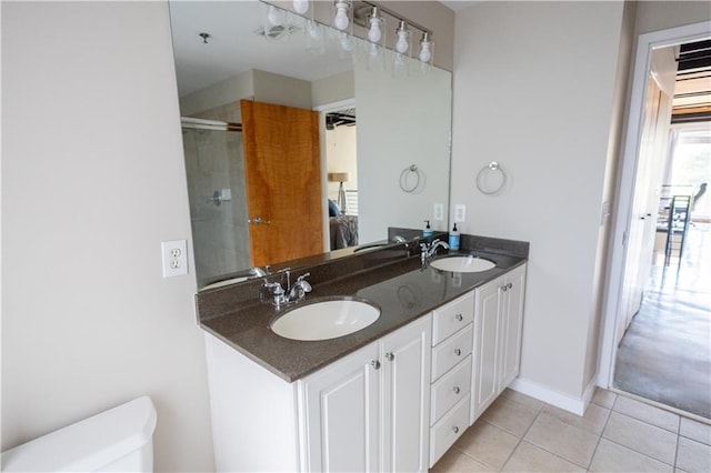 bathroom featuring a shower with door, vanity, and tile patterned floors