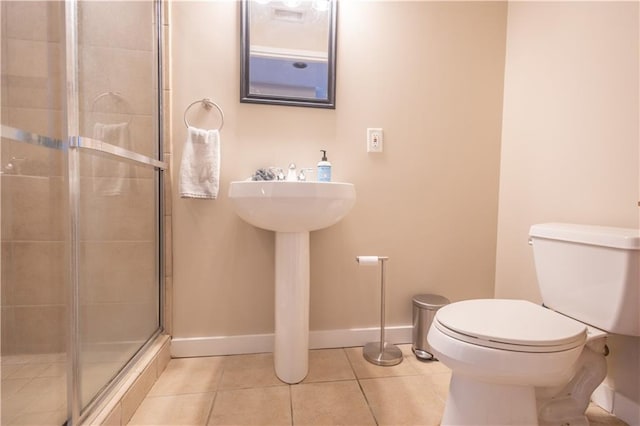 bathroom with toilet, an enclosed shower, and tile patterned floors