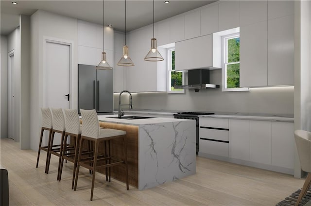 kitchen featuring light hardwood / wood-style floors, a kitchen island with sink, sink, white range oven, and white cabinetry